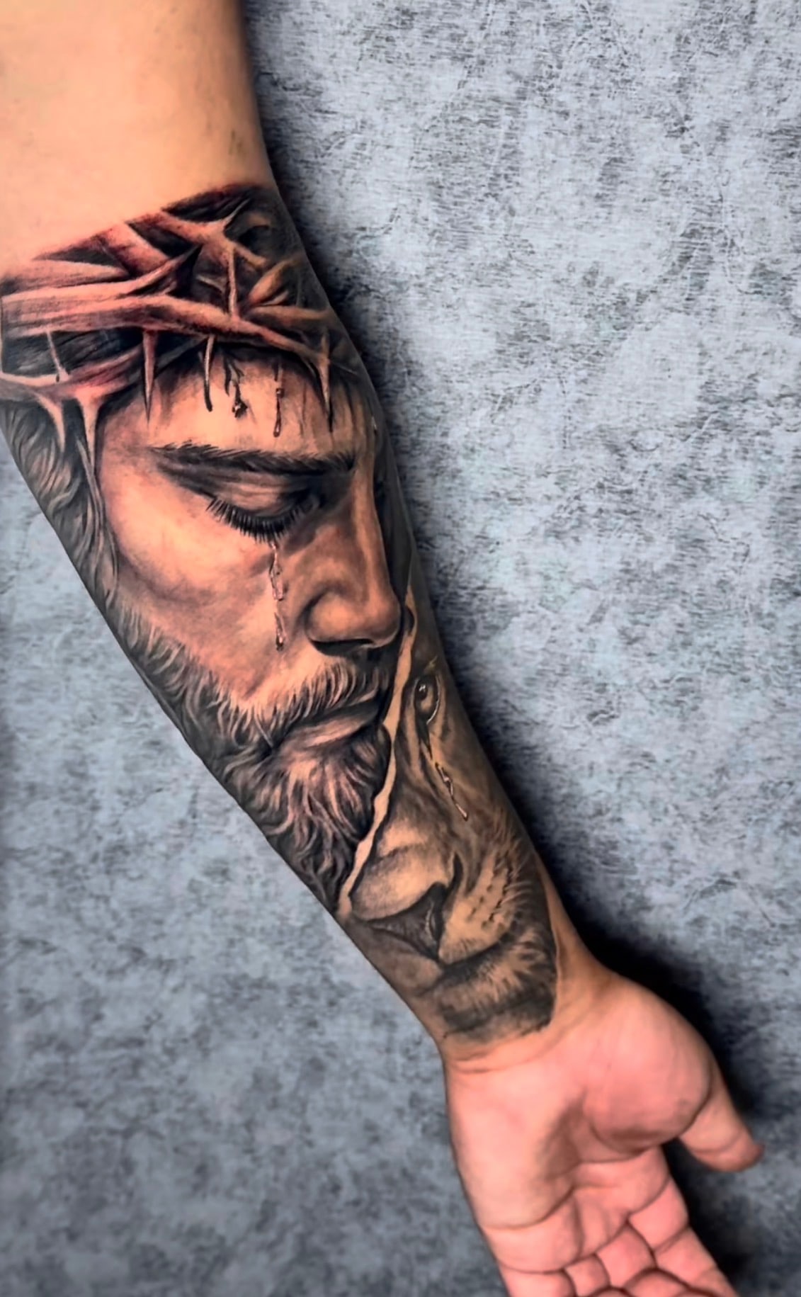 Black and grey realism portrait tattoo with crown of thorns on the forearm, El Artista tattoo studio Hadath